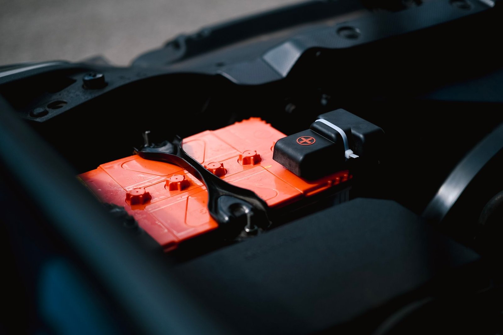 A car battery mounted in the engine bay