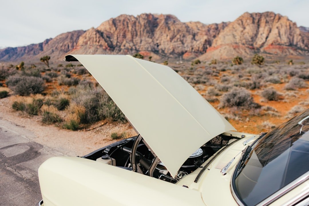 An open car hood in a desert setting