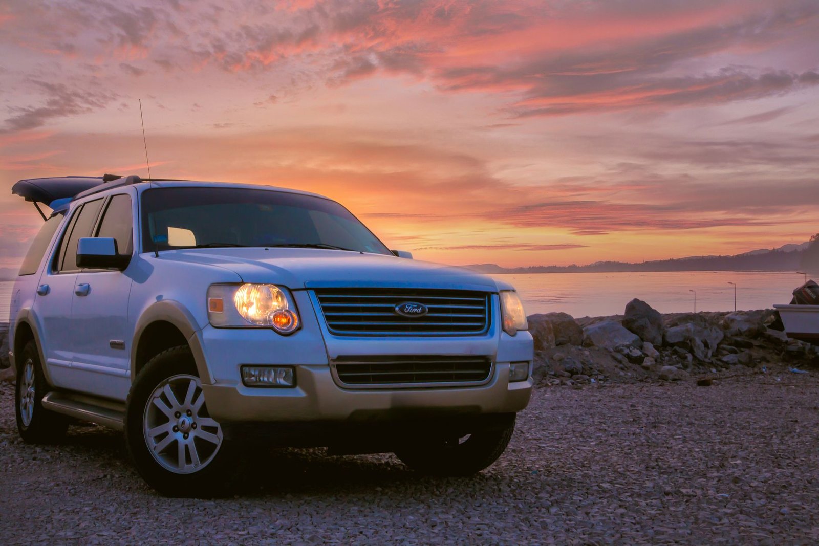 A Ford SUV parked outdoors near water at sunset