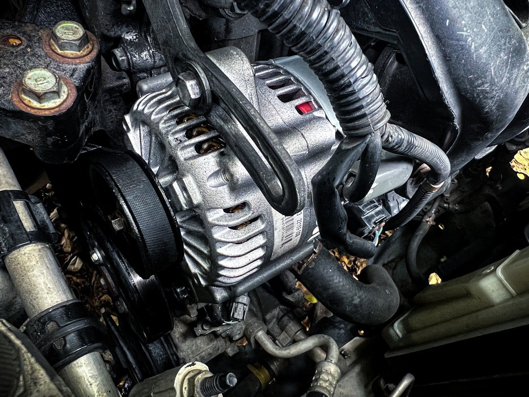 Close-up of a car alternator and belt system in an engine bay