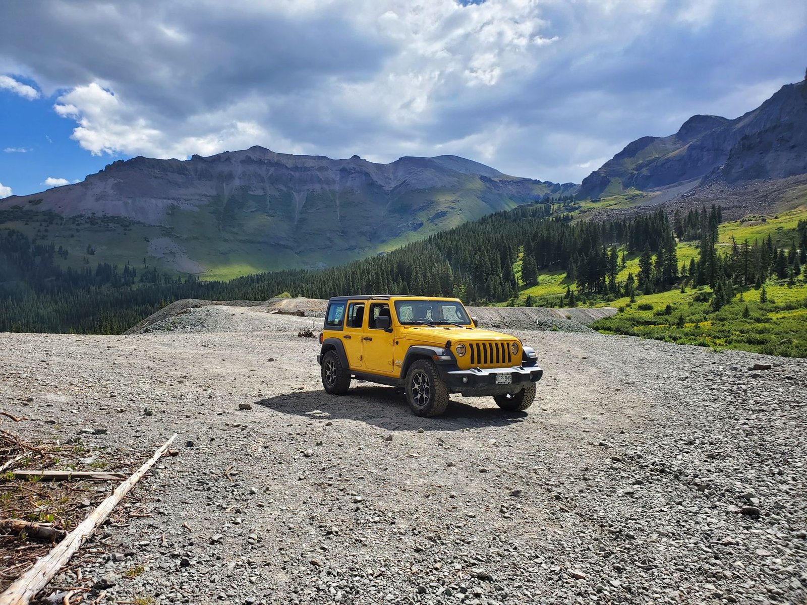 A Jeep Wrangler parked on a mountain trail