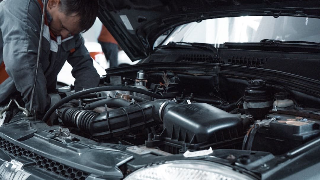 Mechanic performing automotive engine repair in a repair shop