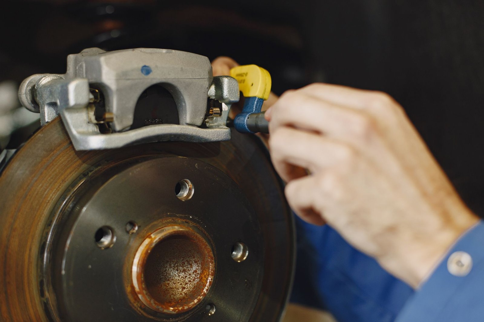 A mechanic inspecting a brake caliper