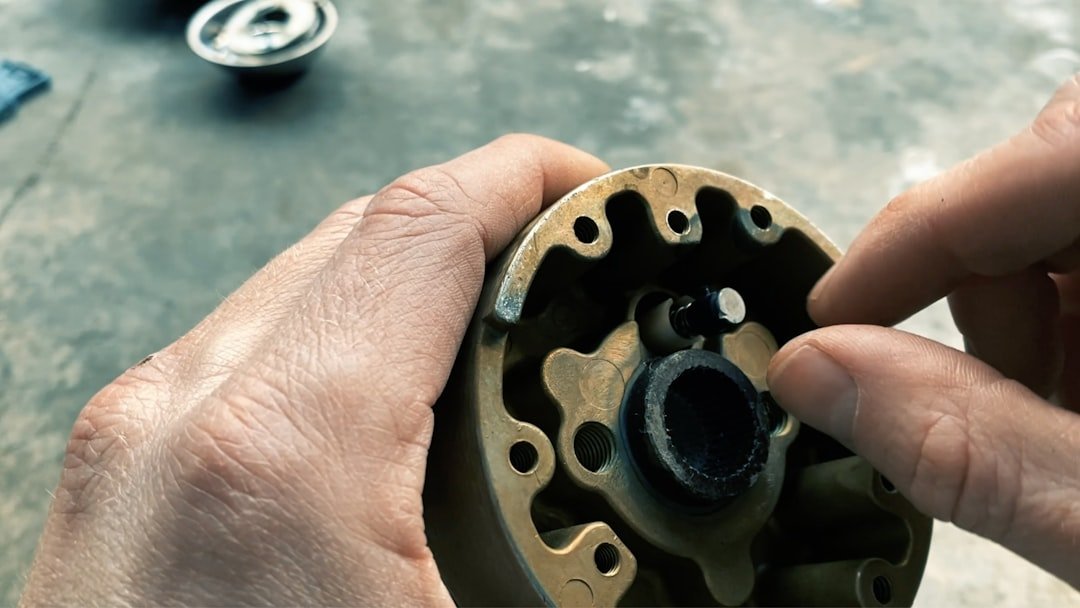 A hand holding a wheel hub part