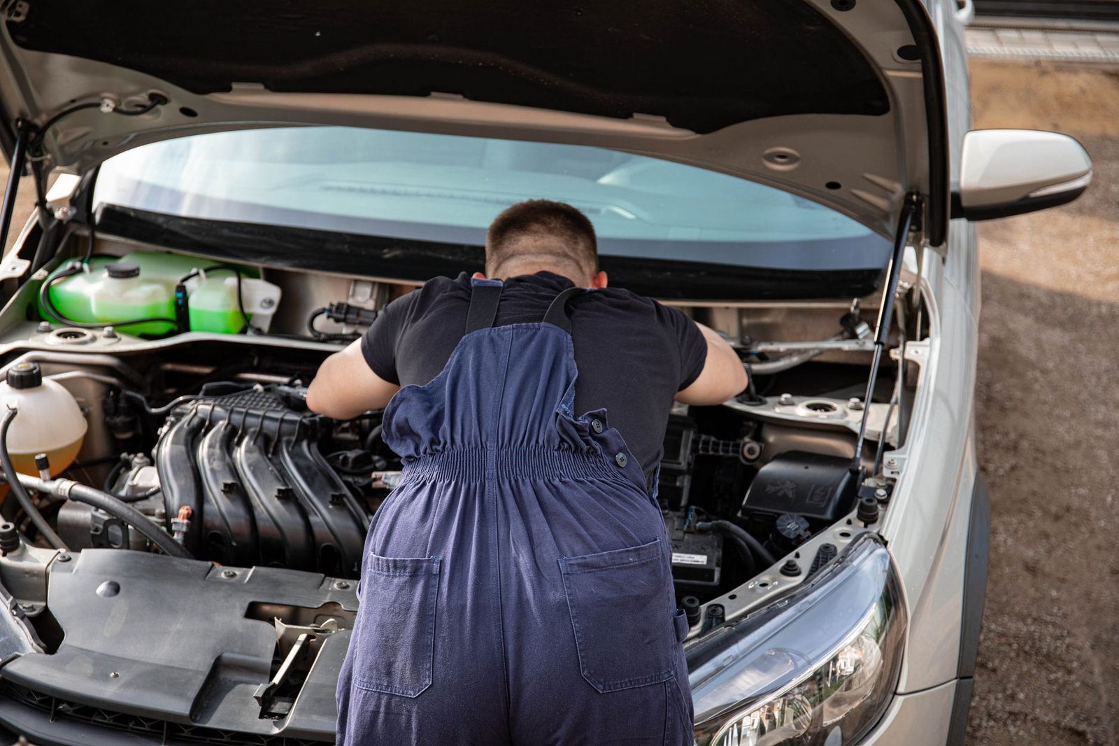 A mechanic inspecting a vehicle's engine under the hood