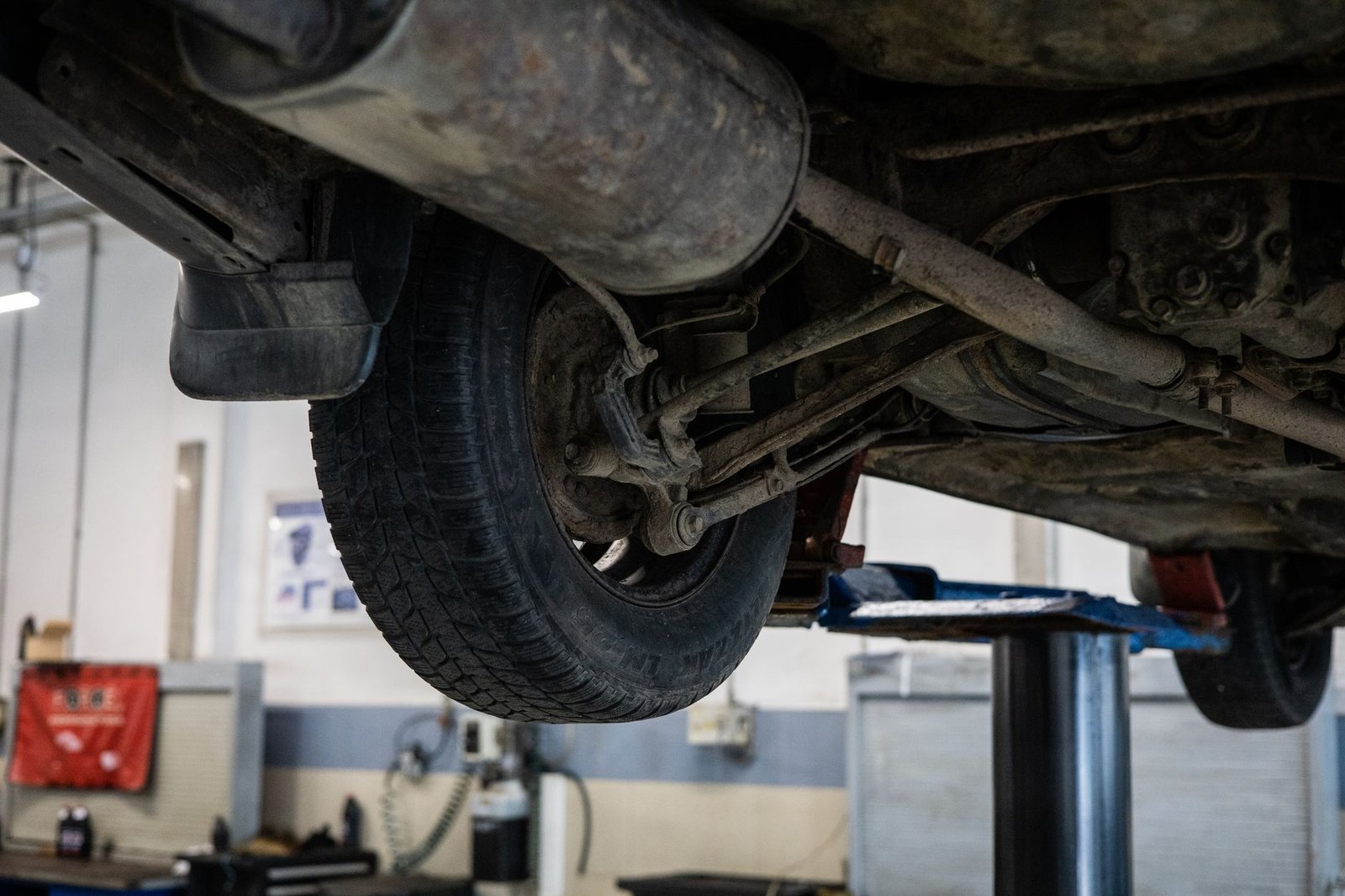 A vehicle raised on a lift showing its underside
