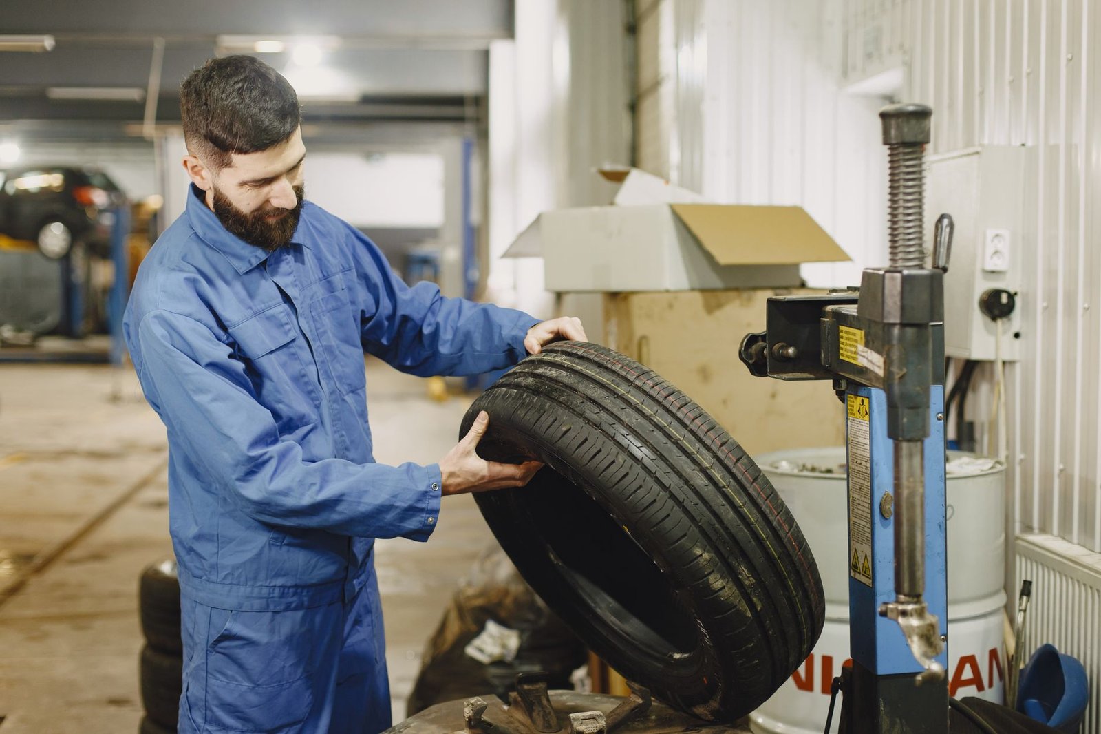 A mechanic handling a tire in a shop