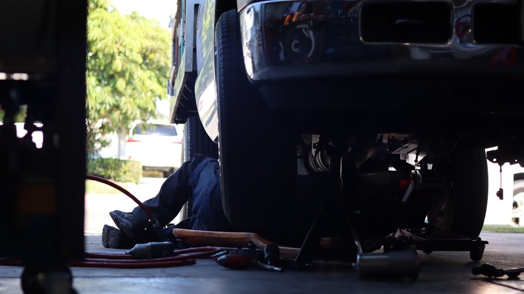 A mechanic working underneath a raised vehicle