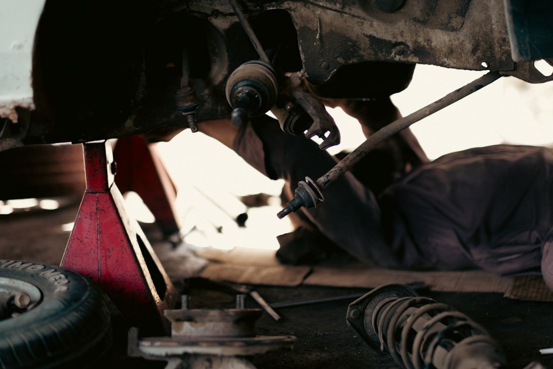 A mechanic working underneath a raised vehicle