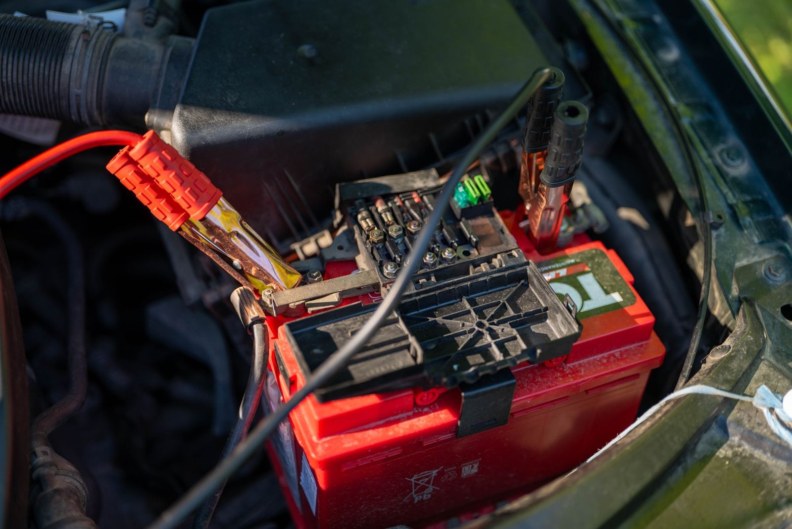 Jumper cables connected to a car battery terminal