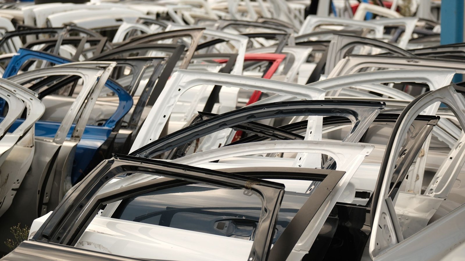 Rows of dismantled car doors and frames in a salvage yard