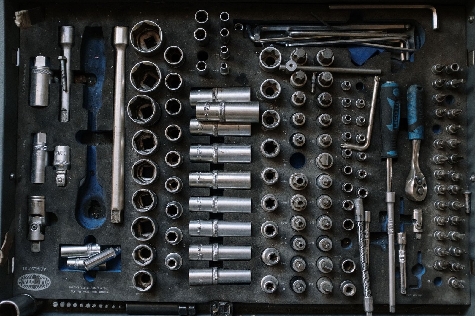 An organized toolbox drawer with sockets and wrenches