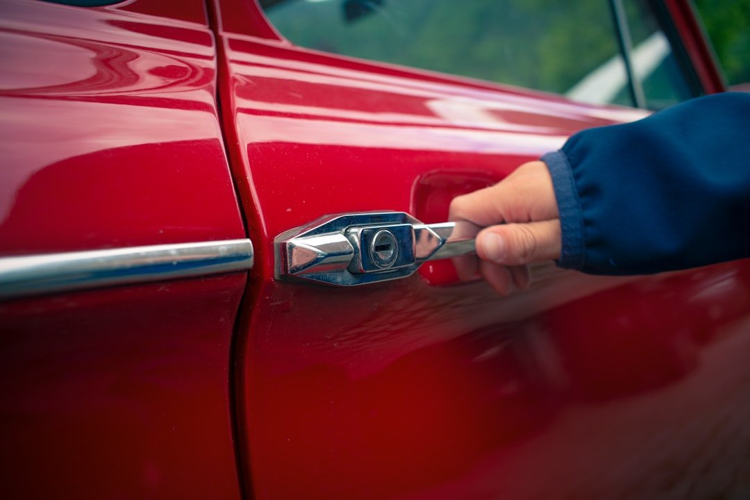 A hand opening a used car door