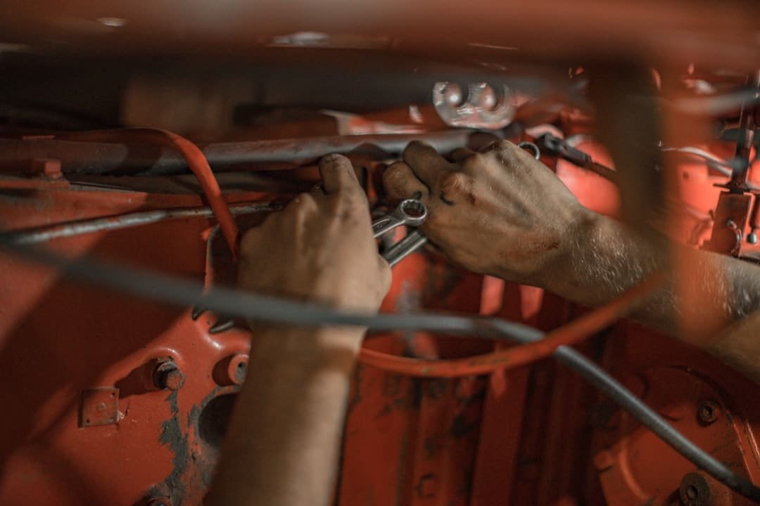 Worker dismantling a salvage vehicle to recover reusable auto parts