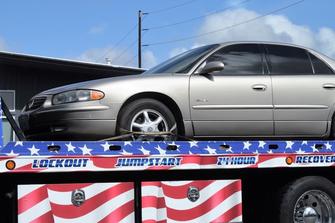 Flatbed tow truck loaded with a vehicle for towing service